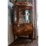 A 19th Century French Bombe walnut vitrine display cabinet, in the Rococo Revival style, having a