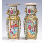 A pair of mid 19th Century Cantonese enamel twin handled baluster vases, decorated in the famille