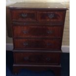 A George III style mahogany chest of drawers, fitted with a brushing slide with two short and
