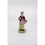 An S. and H. Derby figure of a street seller carrying her wares, standing on a pierced base. Date c.