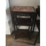 A 19th Century Chinese three-tier occasional table, the top with inset red marble, carved frame,