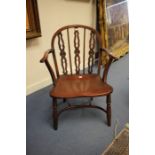 A George III Windsor chair, circa 1810, with shaped and pierced back splats, having an elm saddle