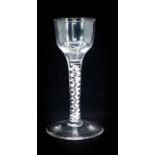 An 18th century wine glass, circa 1755, the plain ogee bowl supported on an opaque, four strand
