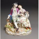 A Meissen figure group of lovers, sitting on a rocky mound, he with a dog at his side, she with a