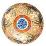 A Chinese famille rose low dish, the central blue and white roundel with a dragon, iron red and gilt