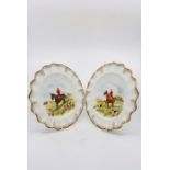 A pair of Royal Crown Derby cabinet plates, each hand painted with hunting scenes, within a fluted