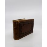 An empty early 20th century leather photograph album with each page having twin double sided oval