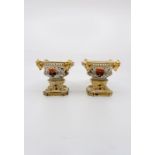 A  pair of Derby pot pourri bases painted in the Imari style, set on four paw feet, mounted on a