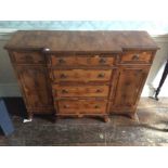 A yew veneered breakfront sideboard, fitted with four long drawers to centre, each side with a