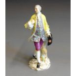 A  Meissen figure of a Gallant striking a pose, dressed in a floral dress coat and bright yellow