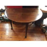 A George III mahogany drop leaf table, standing on off centre turned legs with pad feet terminals