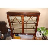 An Edwardian mahogany display cabinet, circa 1905, fitted with two glazed doors, enclosing two