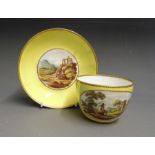 A Pinxton porcelain tea cup and saucer, yellow ground painted with landscapes within gilt cartouches