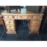 A 20th Century pine twin pedestal desk, 77cm high, 125cm wide, 64cm deep