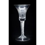 A mid 18th Century wine glass with a flared trumpet bowl, an air twist stem on a conical foot. 189mm