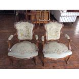 A pair of 19th Century French Rococo revival open armchairs, woolwork seats, carved backs,