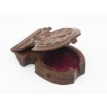 A carved wooden fob watch holder with oak leaf design