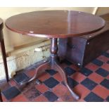 A George III oak tripod table, standing on a turned column with three cabriole legs