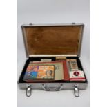 A small flight case containing cigarette cards and packets.