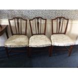 A set of four George III mahogany cream upholstered side chairs, in the Sheraton style, raised on