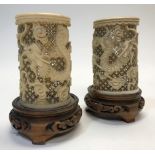 A pair of Chinese ivory cylinder vases, late 19th or early 20th Century, carved with dragons chasing
