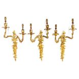 A suite of three gilt ormolu double light girandoles, probably French early 20th Century, of