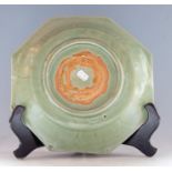 A Chinese Longquan celadon octagonal dish, late Ming dynasty, carved with a central lotus flower,