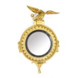 A Regency design gilt wood wall convex looking glass, 19th Century, surmounted with an eagle holding