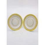 Two Derby twist fluted edge plates with a yellow band and gilt borders, Exhibition label on reverse,