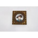 A porcelain hand painted miniature portrait, having a wooden surround and gilt mounts. Size 10.5cm.