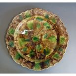 A large Whieldon pottery platter with a fluted rim, typically decorated in browns, greens and ochre,