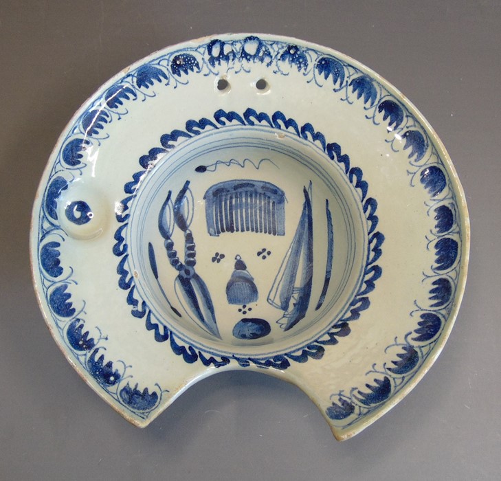 An English delft blue and white barber's bowl decorated with barber's tools, circa 1725, 26cm