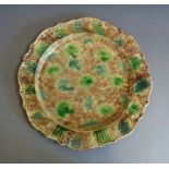 A large Whieldon pottery platter with a fluted rim, typically decorated in greens browns and