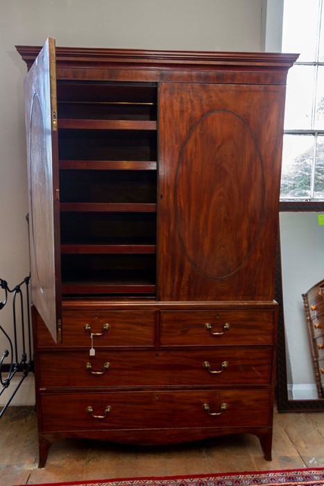 A George III mahogany linen press, the upper section with two doors opening to reveal sliding