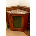 A 19th Century marble topped corner cupboard with metal lattice work door panel