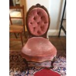 A mid Victorian walnut carved oval backed nursing chair, deep button back, upholstered seat, 92cm