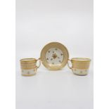 A Derby trio coffee can, tea cup and saucer. White and gilt decoration. Date circa 1825, red mark.
