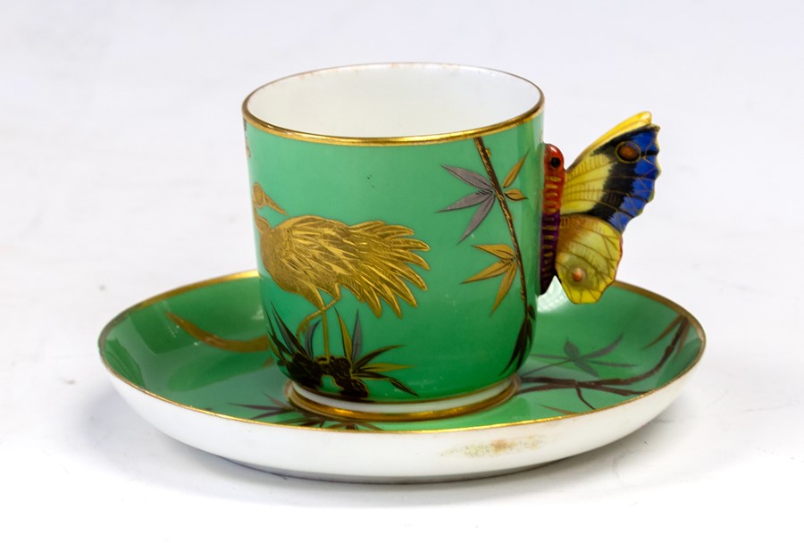 A Royal Worcester coffee can and saucer, painted in green with a bird and a branch in the