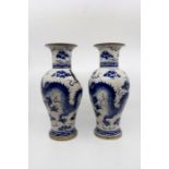 A pair of 20th Century blue and white vases in antique style depicting Qiulong dragon amongst