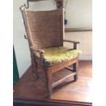 An early 20th Century Arts and Crafts Liberty Orkney Children's armchair, with green straw filled