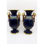 A pair of 19th century majolica vases, cockatoo on scrolled bamboo handles, the main body dark