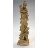A Japanese ivory okimono of a man upon a tree stump with a scroll and an infant below, Meiji period,