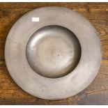 A wide rimmed pewter bowl. Touch marks to underside of rim with a faded London mark. 14 inch.