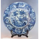 A large Japanese blue and white circular charger, mid 17th Century, decorated with central panel