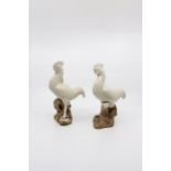 Pair of Chinese Blanc de chine figures of cockerels perched on unglazed outcrops, H. approx 20