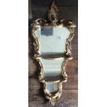 A 19th Century gilt wood set of wall shelves, of Rococo design, four graduated tiers with a mirror
