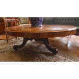 A Victorian large oval walnut centre table, the tilt-top on turned column, three carved legs