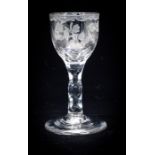 A mid 18th Century cordial glass, the bowl decorated with wheel etching, raised on a multi faceted
