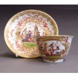 A Meissen tea bowl and saucer, painted with chinoiserie scenes and lavish gilding, the reverse has