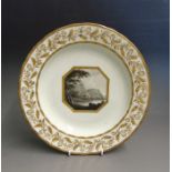 A Derby porcelain shallow dish with a wide gilt decorated border, the central landscape of  ‘Lowdore